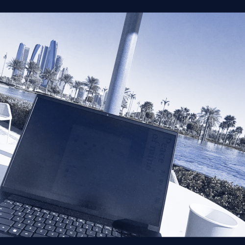 Laptop on the table with a view over water and skyscrapers